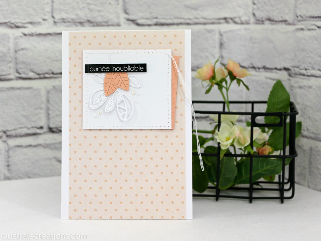 Carte d'anniversaire en blanc-saumon avec fond petits pois et un cadre avec feuillages, étiquette et une bordure couture.