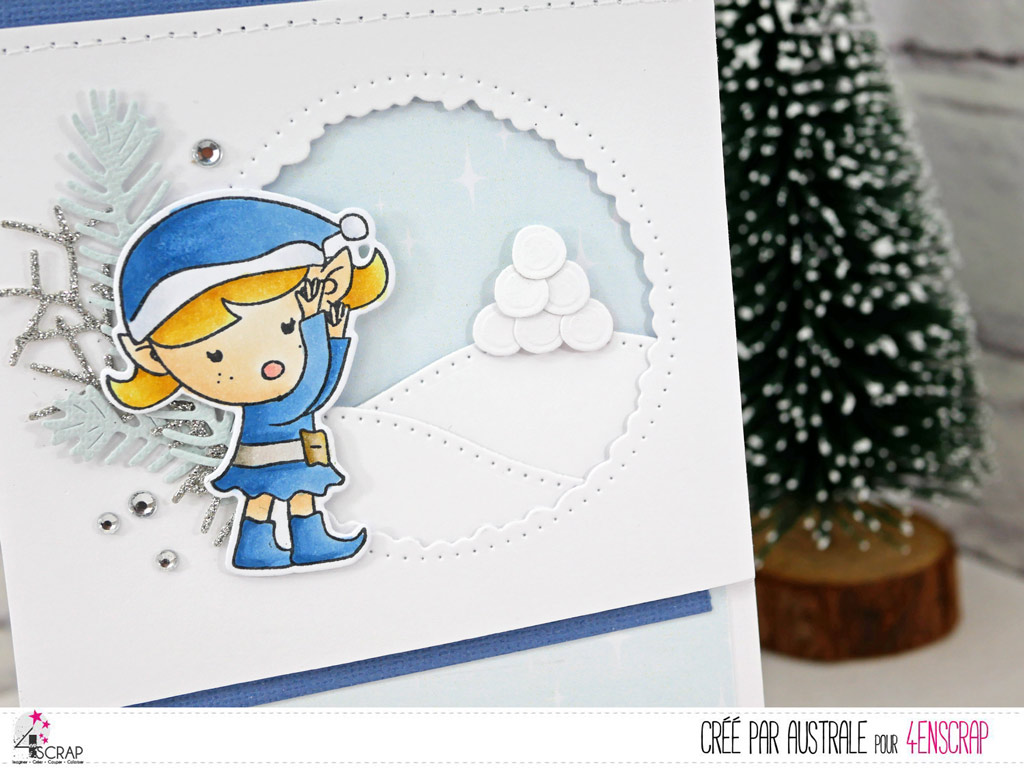 Carte de Noël dans les tons de bleus avec fenêtre sur collines enneigées et une petite lutine de Noël.