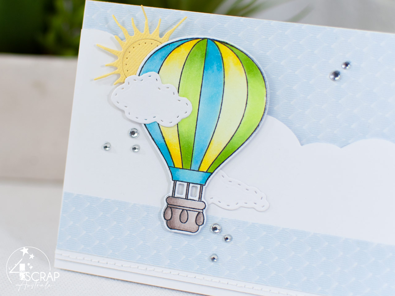 Création d'une carte à tirer avec une montgolfière sur fond nuages, soleil et la bannière qui apparait.