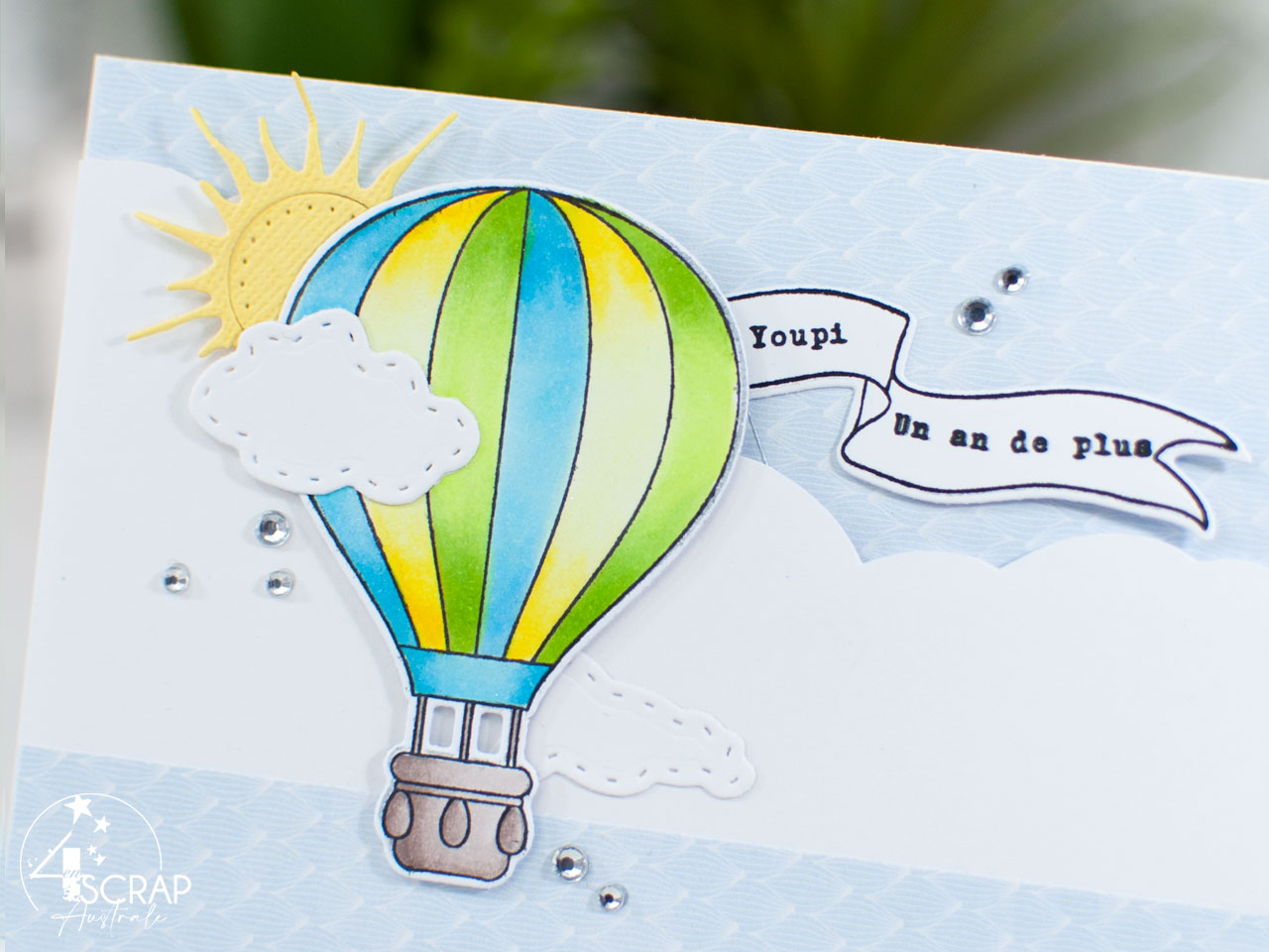 Création d'une carte à tirer avec une montgolfière sur fond nuages, soleil et la bannière qui apparait.