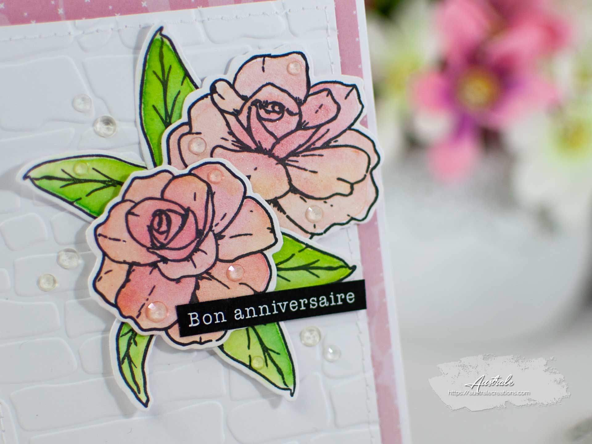 Création d'une carte pour anniversaire. Elle est décorée de fleurs et feuillages mis en couleurs à l'aquarelle dans un combo en rose, blanc et vert.