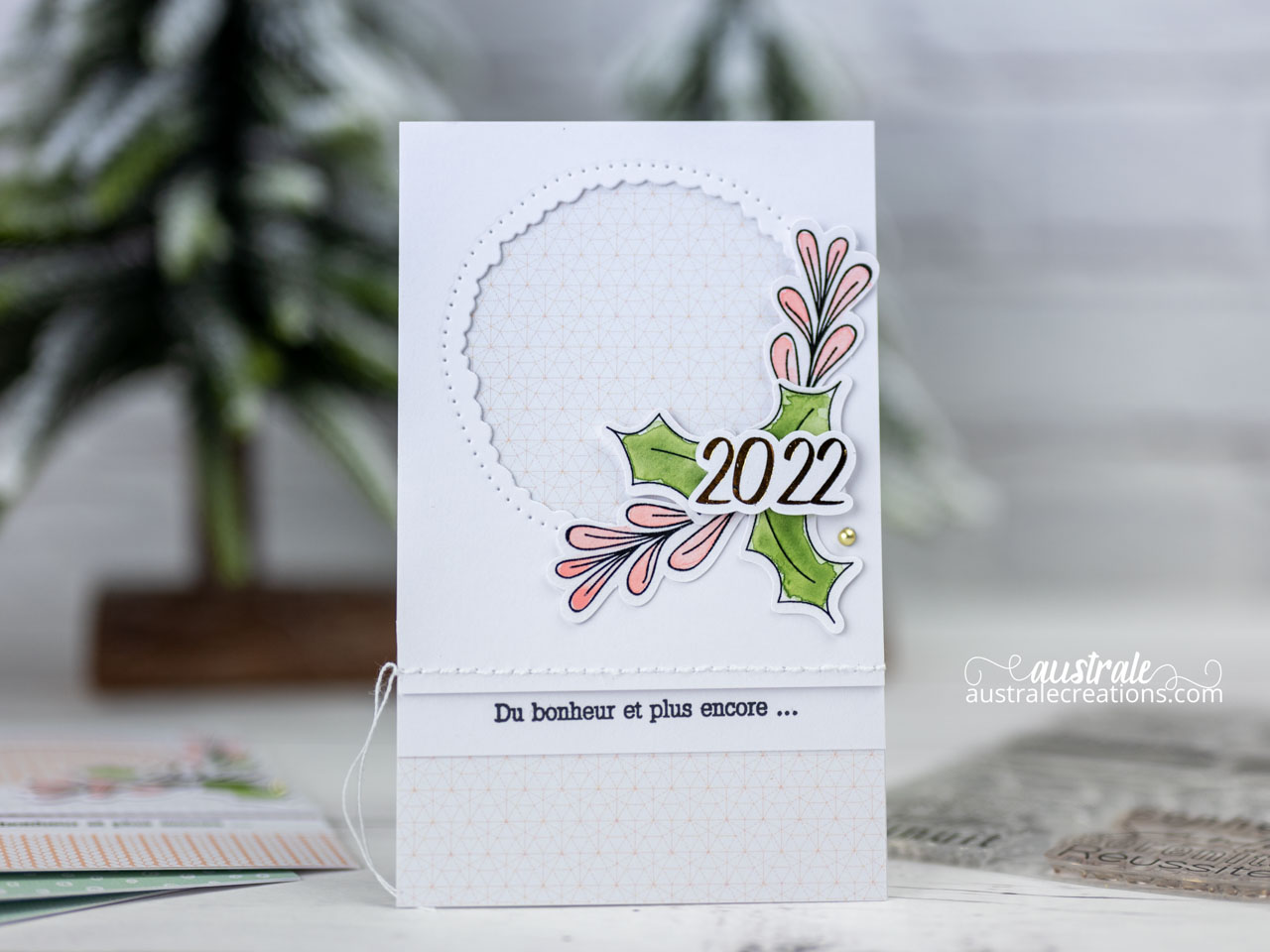 Création d'une carte de vœux en série avec tampons digitaux découpés à la Caméo et mis en couleur à l'aquarelle, l'année est embellie au foil et une fenêtre est ouverte sur les jolis papiers imprimés de 4enscrap.