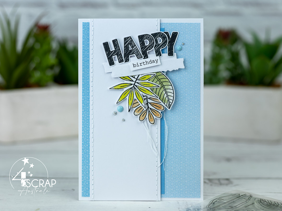 Création d'une carte d'anniversaire sur le thème Voyage exotique de 4enscrap. On y voit le mot Happy en grosses lettres et un cluster de feuilles exotiques à l'aquarelle.